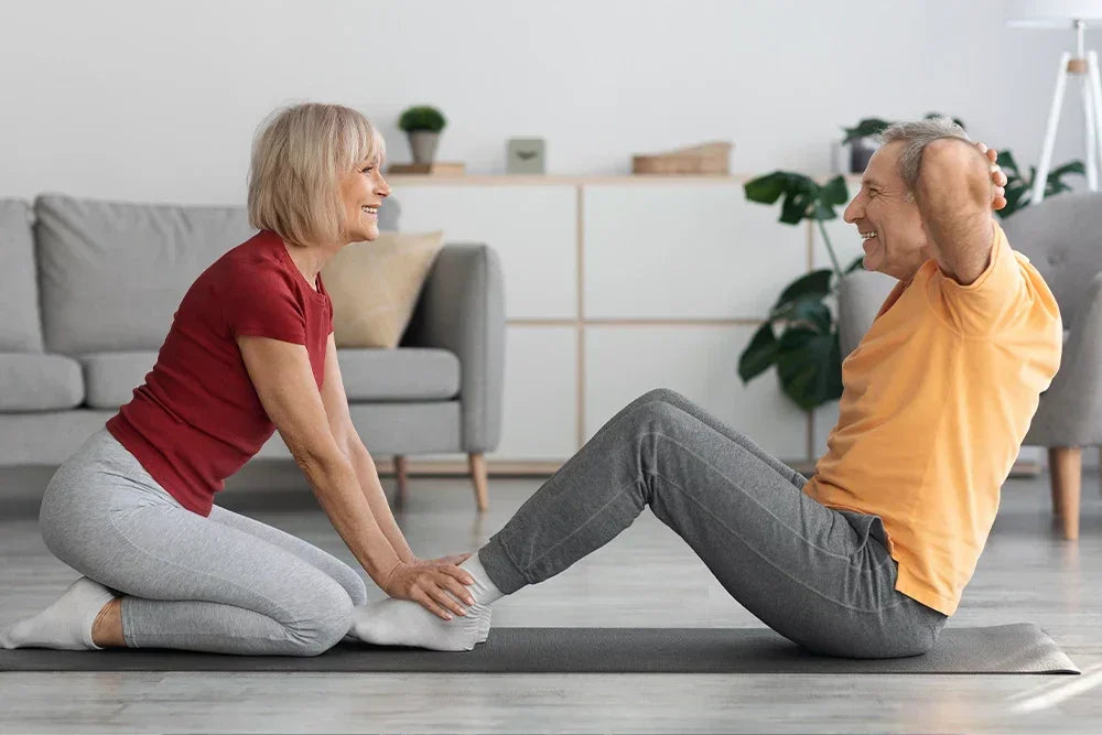 Une femme et un homme font du sport ensemble à la maison – des exercices de remise en forme en douceur pour le printemps, la motivation et l'énergie