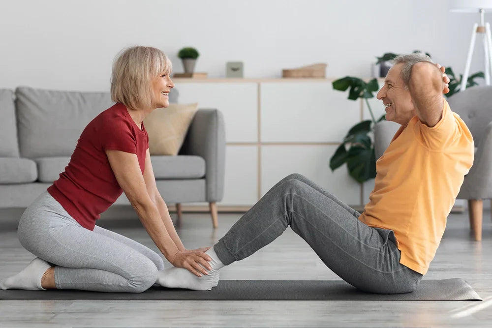 Une femme et un homme font du sport ensemble à la maison – des exercices de remise en forme en douceur pour le printemps, la motivation et l'énergie
